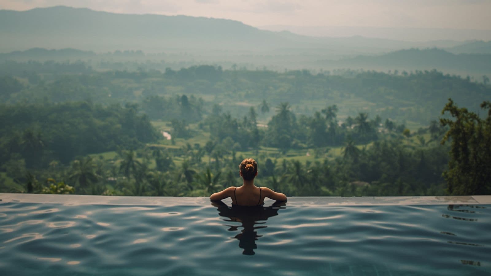 Femeie într-o piscină infinită cu vedere spre junglă și orezării, în Bali
