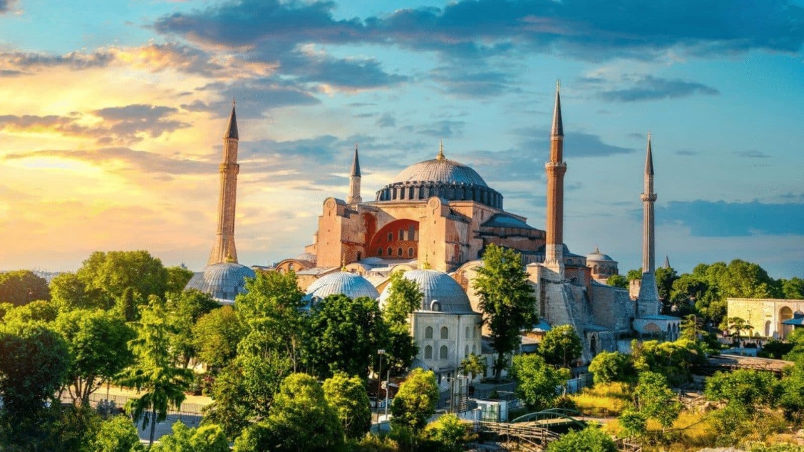 Sfânta Sofia din Istanbul, cu cupolele și minaretele ei, la apus, deasupra copacilor